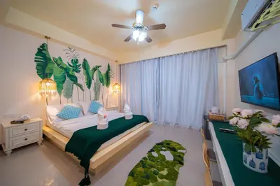 a bedroom with a bed with a green blanket and a ceiling at Patong Beach Side Hotel in Patong Beach