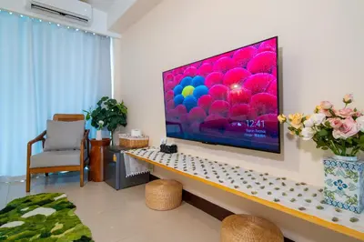 a living room with a large television on a wall at Patong Beach Side Hotel in Patong Beach