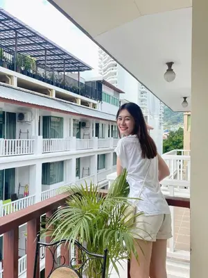 a woman standing on the balcony of a building at Patong Beach Side Hotel in Patong Beach