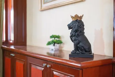 a statue of a lion wearing a crown on a dresser at The Phuket Pool Villa in Phuket Town
