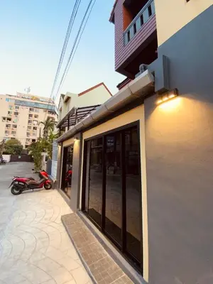 a building with glass doors and a scooter parked outside at Patong Sea U in Patong Beach