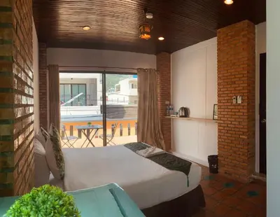 a bedroom with a large bed and a balcony at Patong Sea U in Patong Beach