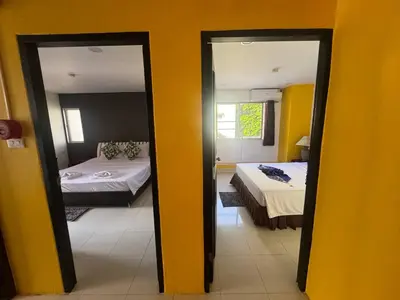 a room with two beds and two mirrors at Patong Sea U in Patong Beach