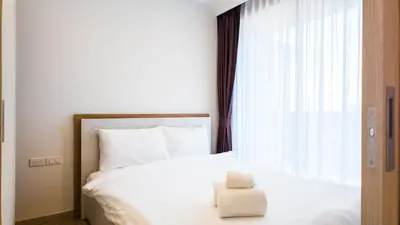 a white bed with a white towel sitting on it at Апартаменты в Лагуне SkyPark c видом на гольф поле in Bang Tao Beach