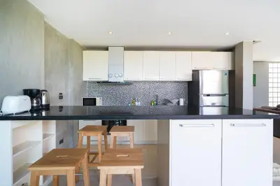 a kitchen with white cabinets and a black counter top at Villa Natural Touch A3 in Kamala Beach