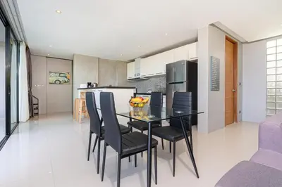 a kitchen and dining room with a black table and chairs at Villa Natural Touch A3 in Kamala Beach