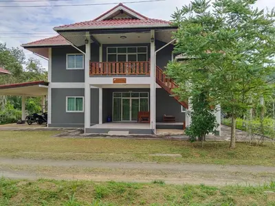 a house with a porch and a balcony at Thanid House in Ban Nai Khlong