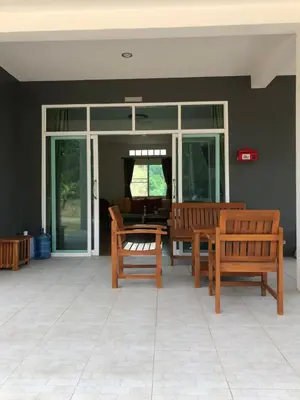 two wooden benches sitting on top of a patio at Thanid House in Ban Nai Khlong