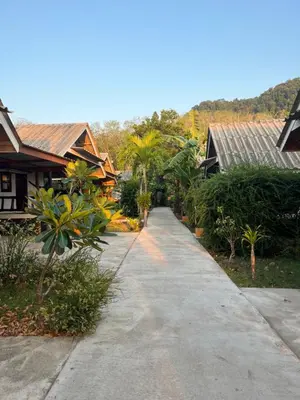 a path in a village with houses and trees at Pyramid Bangalow in Ban Laem Sai