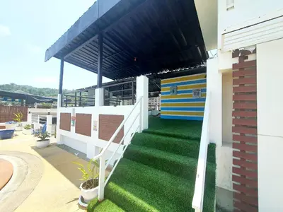 a patio with a white fence and green grass at Issara Patong Beach in Patong Beach