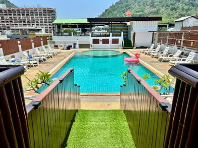 a large swimming pool with chairs and a pink inflatable at Issara Patong Beach in Patong Beach