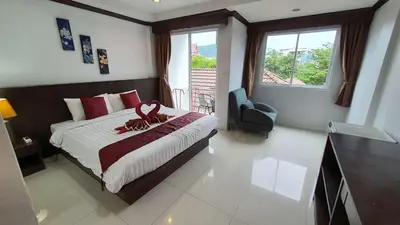 a bedroom with a bed with a stuffed animal on it at \u6c34\u679c\u5929\u5802\u65c5\u9986Fruit Paradise in Patong Beach