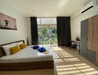a bedroom with a large bed with blue flowers on it at Kata Sea Blue in Kata Beach