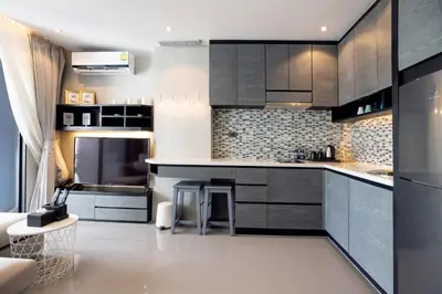 a kitchen with black and white cabinets and appliances at Tropics Kamala Pool View Studio CTG B608 in Kamala Beach
