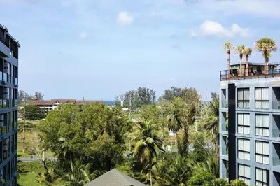 a view of a building with palm trees at Tropics Kamala Pool View Studio CTG B608 in Kamala Beach