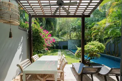 a patio with a table and chairs under a pergola at Your Private Paradise - 2BR Tropical Pool Villa Astree in Rawai Beach