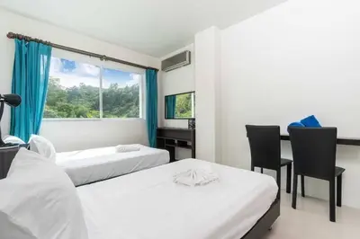 a bedroom with two beds and a desk and a window at Royal Kamala - Peaceful Private Rooftop Pool Apartment in Kamala in Kamala Beach