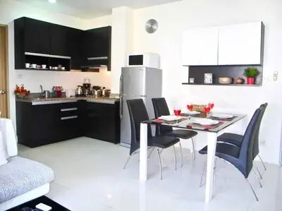 a kitchen with a table and chairs in a kitchen at Royal Kamala - Peaceful Private Rooftop Pool Apartment in Kamala in Kamala Beach