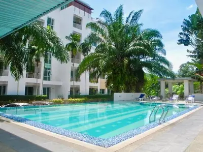 a swimming pool in front of a building with palm trees at Royal Kamala - Peaceful Private Rooftop Pool Apartment in Kamala in Kamala Beach