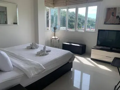 a bedroom with a bed and a flat screen tv at Royal Kamala - Peaceful Private Rooftop Pool Apartment in Kamala in Kamala Beach