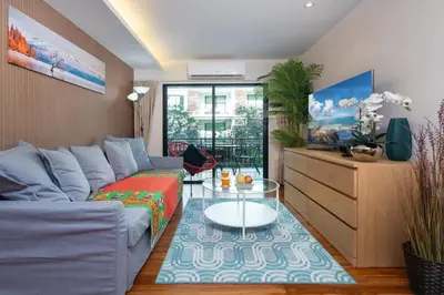 a living room with a couch and a table at The Title Rawai West Wing Pool View Suite in Rawai Beach
