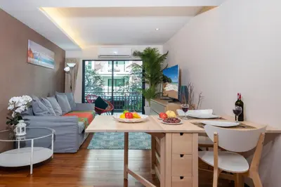 a living room with a table and a couch at The Title Rawai West Wing Pool View Suite in Rawai Beach