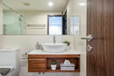 a bathroom with a sink and a mirror and a toilet at The Title Rawai West Wing Pool View Suite in Rawai Beach