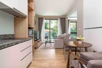 a kitchen and living room with a table and a couch at Diamond Apartments Phuket Bangtao in Phuket Town