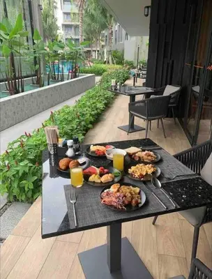 a black table with plates of food on it at Diamond Apartments Phuket Bangtao in Phuket Town