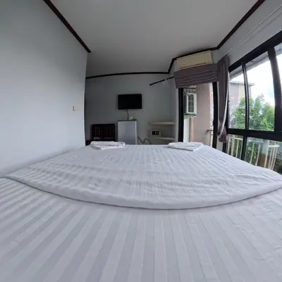 a large white bed in a room with windows at Hotel premier in Patong Beach