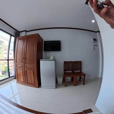 a person taking a picture of a room with a refrigerator at Hotel premier in Patong Beach
