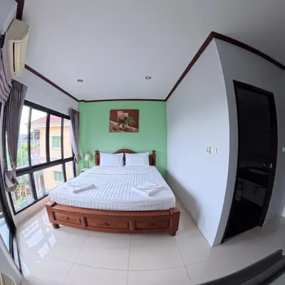 a bedroom with a bed in a room with green walls at Hotel premier in Patong Beach
