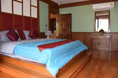 a bedroom with a large bed with blue sheets at VILLA SIRINTHARA in Rawai Beach