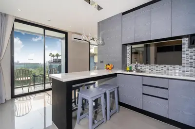 a kitchen with a counter with stools and a large window at Tropics Kamala 2BR Pool View Apartment CTG B705-6 in Kamala Beach