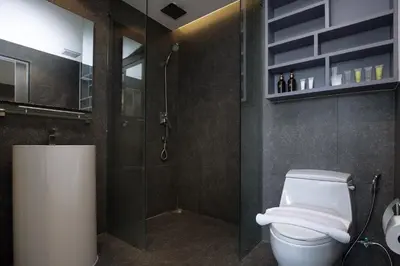 a bathroom with a white toilet and a shower at Tropics Kamala 2BR Pool View Apartment CTG B705-6 in Kamala Beach