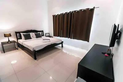 a bedroom with a bed and a desk and a television at Large Penthouse 3BR with jacuzzi, Best for Kids in Karon Beach