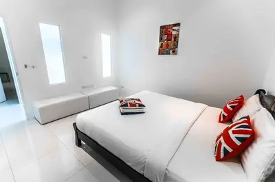 a white bedroom with a bed with red pillows at Large Penthouse 3BR with jacuzzi, Best for Kids in Karon Beach