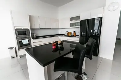 a kitchen with a black counter and black appliances at Large Penthouse 3BR with jacuzzi, Best for Kids in Karon Beach