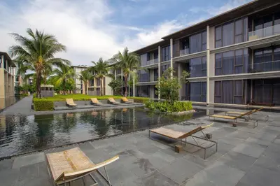 a building with a pool in front of a building at Baan Mai Khao by Villacarte in Mai Khao Beach