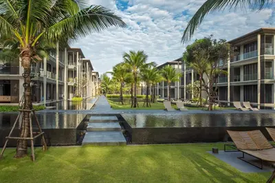 a resort with a canal and palm trees and buildings at Baan Mai Khao by Villacarte in Mai Khao Beach