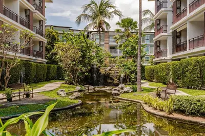 a garden with a pond in front of buildings at Title III and II by Villacarte in Rawai Beach