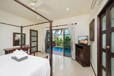 a bedroom with a bed and a television in it at Villa Ikaroa Private pool villa Kokyang Estate in Nai Harn Beach