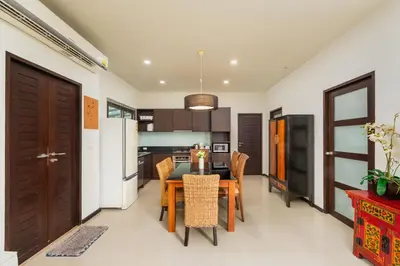 a kitchen and dining room with a table and chairs at Villa Ikaroa Private pool villa Kokyang Estate in Nai Harn Beach