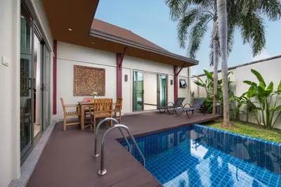 a house with a wooden deck and a swimming pool at Villa Ikaroa Private pool villa Kokyang Estate in Nai Harn Beach