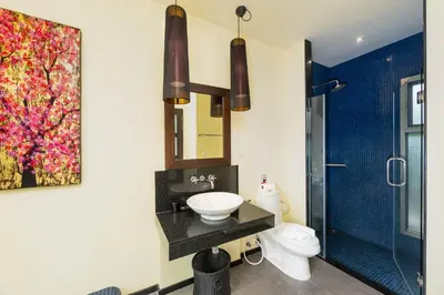 a bathroom with a sink and a toilet and a mirror at Villa Ikaroa Private pool villa Kokyang Estate in Nai Harn Beach