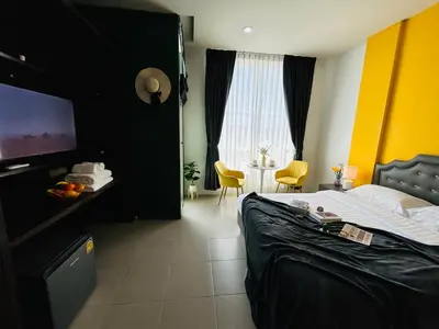 a hotel room with a bed and a table with chairs at Studio room in Mango House in Phuket Town