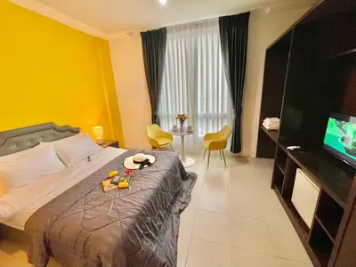 a hotel room with a bed and a television at Studio room in Mango House in Phuket Town