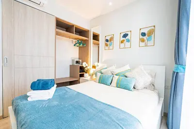 a bedroom with a large bed with blue accents at Laguna Skypark by My Home Phuket in Bang Tao Beach