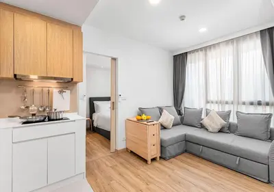 a living room with a gray couch in a kitchen at Laguna Skypark by My Home Phuket in Bang Tao Beach