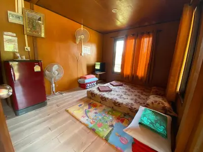 a small bedroom with a bed and a table at Patcharin Homestay in Ban Lo Pla Lai (1)